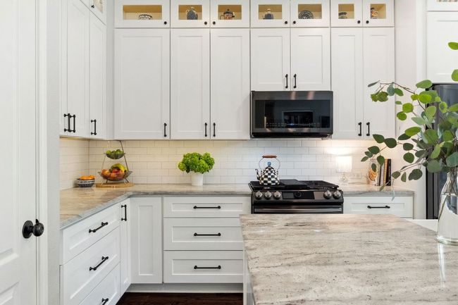 The kitchen is beautifully updated with granite countertops, floor-to-ceiling soft-close cabinetry, and hardware by Restoration Hardware. | Image 9