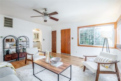 Enter into this spacious living room with clean lines and large windows. | Image 3