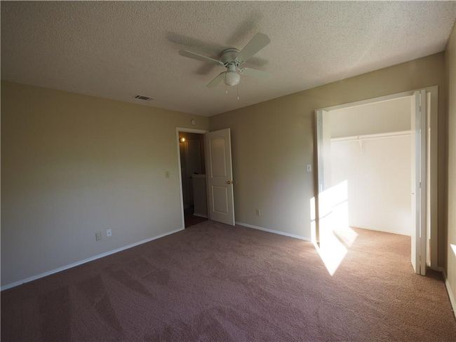 Unfurnished bedroom with carpet flooring, a textured ceiling, baseboards, and a ceiling fan | Image 15