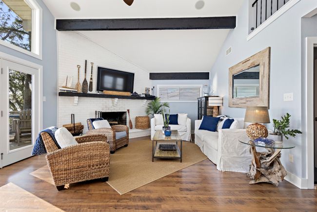 Open concept living featuring wood beems, vaulted ceiling and wood burning fireplace. | Image 8