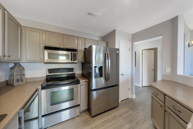 Kitchen featuring stainless steel appliances, light countertops, light wood laminate flooring | Image 5