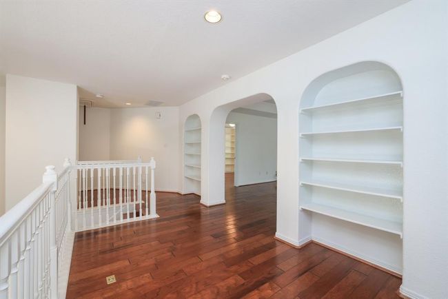 At the top of the full wood staircase is three arched areas perfect for books or family photos. entrance to large gameroom. | Image 23