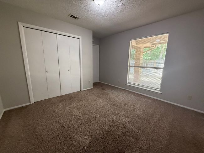 Unfurnished bedroom featuring a closet, carpet floors, and a textured ceiling | Image 17