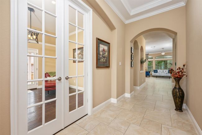 Corridor with crown molding, arched walkways, and french doors | Image 11