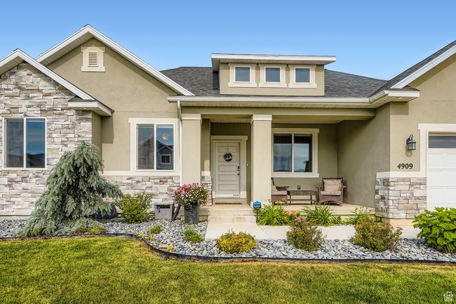 View of exterior entry featuring stone siding, covered porch, and stucco siding | Image 26