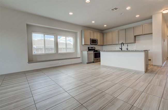 Kitchen with appliances with stainless steel finishes, tasteful backsplash, light countertops, gray cabinets, and recessed lighting | Image 13