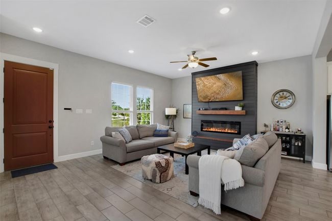 Living area with a fireplace, baseboards, a ceiling fan, recessed lighting, and light wood-style flooring | Image 4