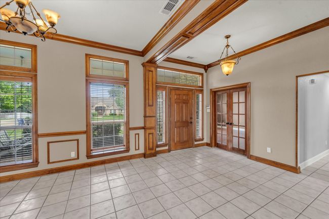 Entryway with a chandelier, crown molding, light tile patterned floors, and french doors | Image 17