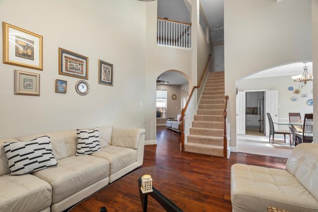 Living area featuring arched walkways, stairs, hardwood / wood-style floors, and a high ceiling | Image 8