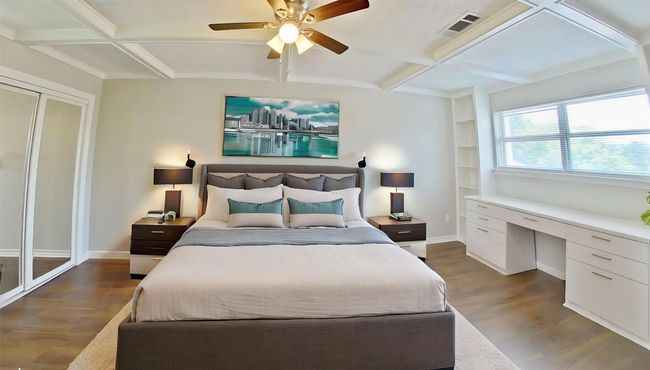 Bedroom with coffered ceiling, beamed ceiling, wood finished floors, and visible vents | Image 11
