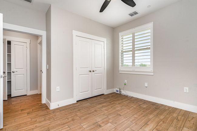 Secondary bedroom featuring light wood finished floors, a closet, baseboards, and a ceiling fan | Image 21