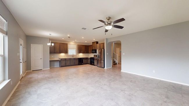 Unfurnished living room with arched walkways, a ceiling fan, visible vents, and baseboards | Image 22