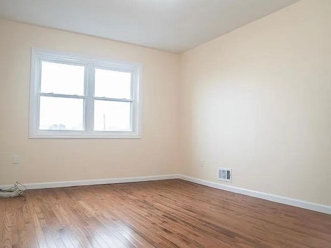 Spare room with visible vents, hardwood / wood-style floors, and baseboards | Image 8