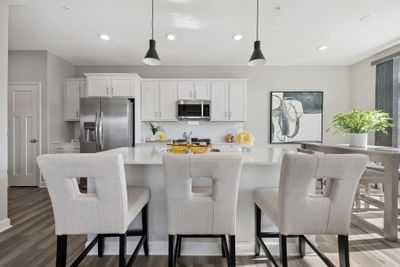 (Photo of a decorated model, actual features will vary) The spacious kitchen features a large center island, quartz countertops, recessed lighting, under mount sink, LVP floors, stainless appliances and more! | Image 1