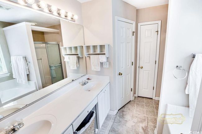 Full bath with a stall shower, double vanity, a bath, and a closet | Image 23