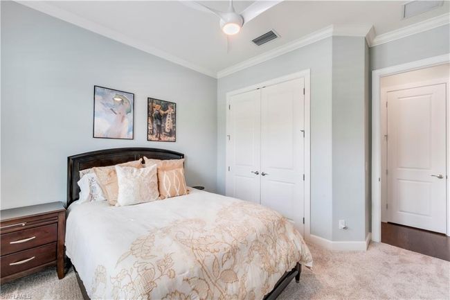 Bedroom with a closet, crown molding, carpet flooring, baseboards, and ceiling fan | Image 28