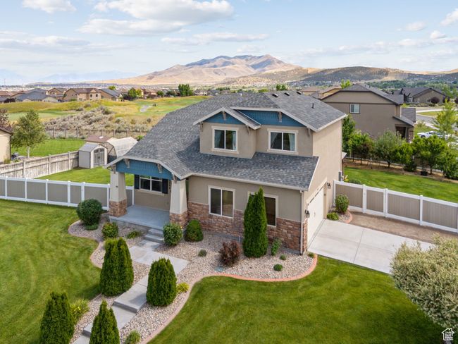 View of front of property featuring stucco siding, stone siding, concrete driveway, and a mountain view | Image 54