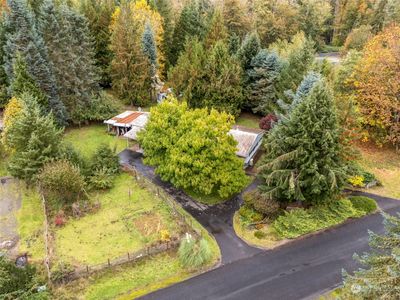 This aerial view captures nearly an acre of pure potential, complete with a charming circular driveway that welcomes you home. With two distinct parking zones, there’s room for your RV or boat—because who wants to leave their weekend adventures behind? This property is not just about living; it’s about embracing a lifestyle where nature and convenience coexist beautifully. Your outdoor escapades are calling, and they’ve got plenty of space! | Image 2