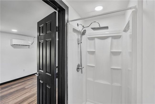 Upstairsbath featuring a shower, baseboards, and wood finished floors | Image 42