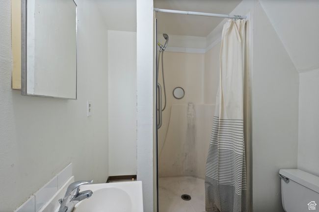 Bathroom with toilet and a shower with shower curtain | Image 29