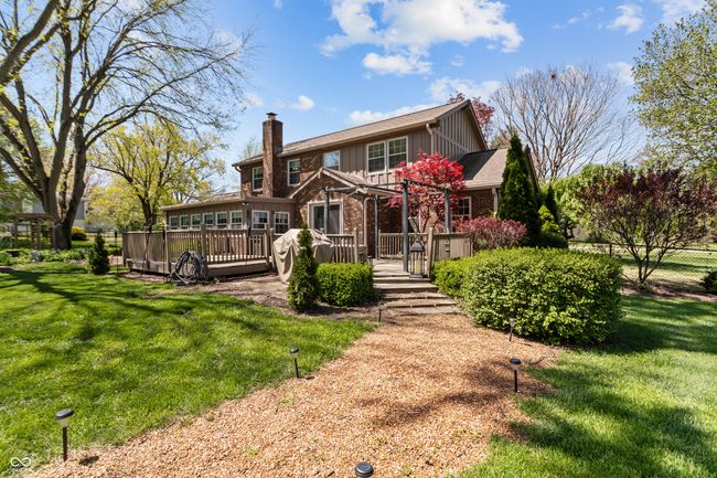 back of house featuring a pergola, a chimney, a deck, board and batten siding, and fence | Image 40