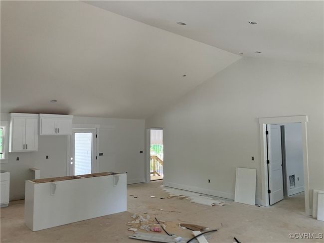 Unfurnished living room featuring high vaulted ceiling and healthy amount of natural light | Image 26