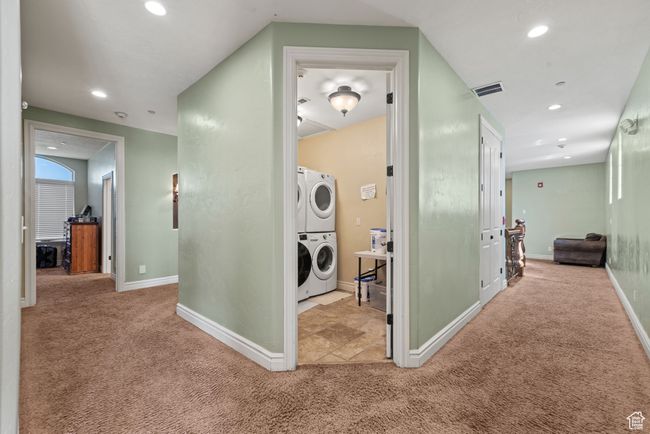 Hallway featuring stacked washing maching and dryer, recessed lighting, visible vents, and carpet floors | Image 40