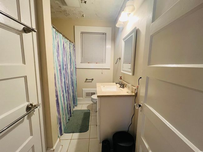 Bathroom featuring visible vents, baseboards, toilet, vanity, and tile patterned flooring | Image 10