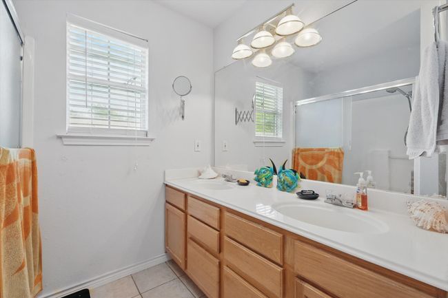 Full bath with tile patterned floors, double vanity, a sink, and a stall shower | Image 26