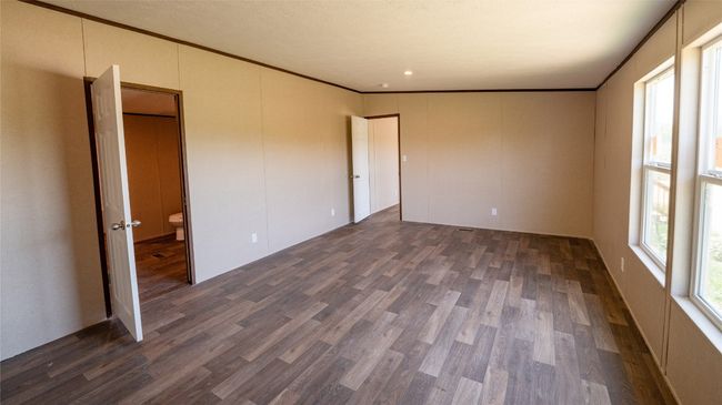 Unfurnished bedroom with dark wood-type flooring and ornamental molding | Image 12