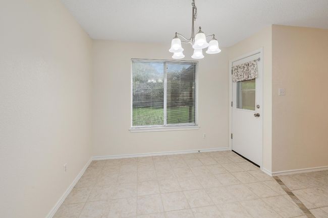 Unfurnished dining area featuring a chandelier and baseboards | Image 7