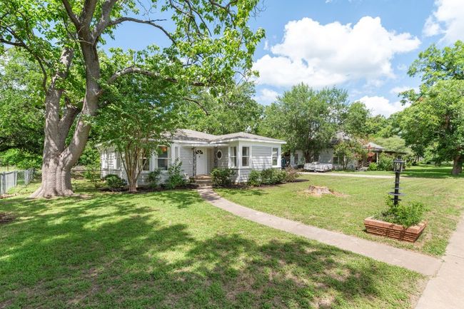 View of front of home from left corner of lot. Lot features original MCM brick planters | Image 26