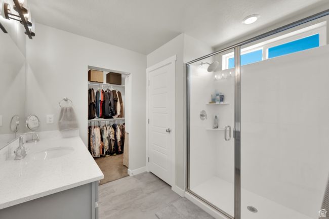 Bathroom with vanity, a stall shower, a spacious closet, and finished concrete flooring | Image 19