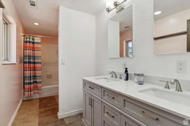 Bathroom featuring double vanity, shower / bath combo and tile patterned floors | Image 18