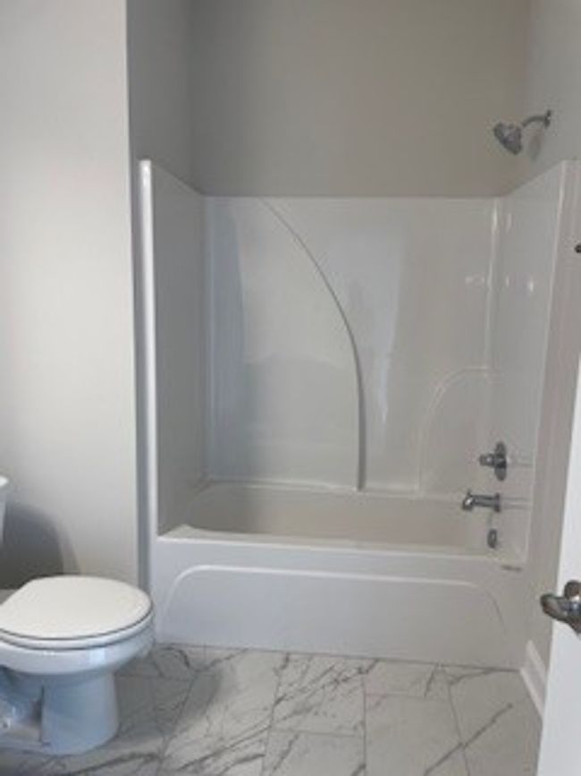 Hall bath with tile floor and quartz counters | Image 17