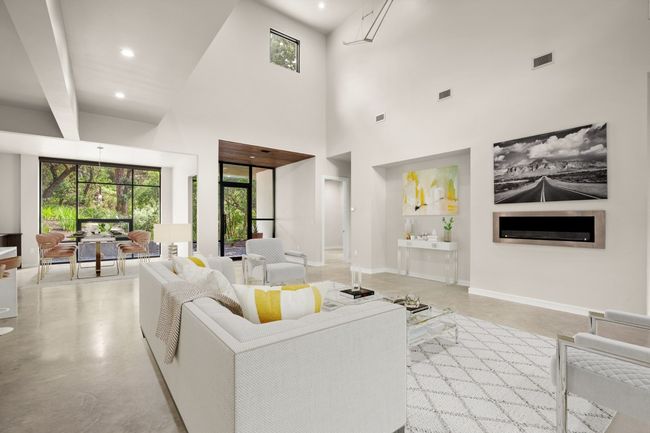 Living room featuring concrete flooring, a high ceiling, baseboards, and recessed lighting | Image 6