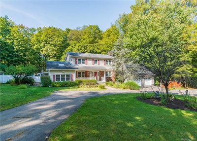 View of front of property featuring a garage, a front yard, and covered porch | Image 1