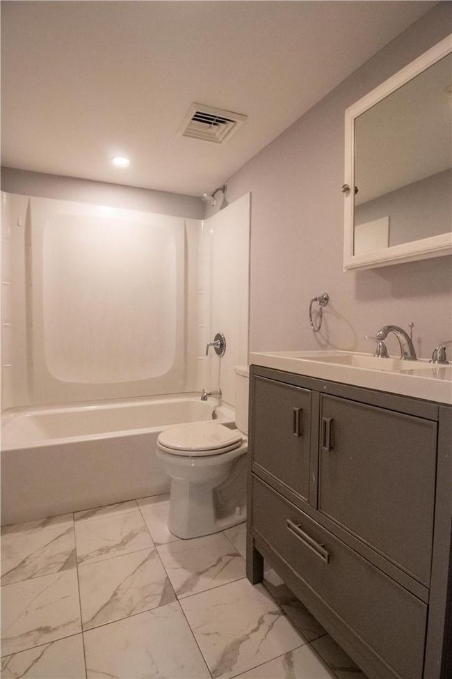 Full bathroom with shower / bathtub combination, vanity, tile patterned flooring, and toilet | Image 11