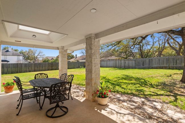 View of patio with a fenced backyard and outdoor dining space | Image 35