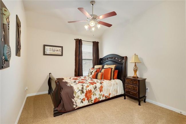 Bedroom featuring carpet flooring, baseboards, vaulted ceiling, and a ceiling fan | Image 16