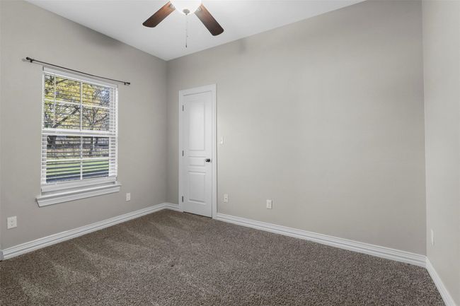 Carpeted empty room featuring ceiling fan and baseboards | Image 7