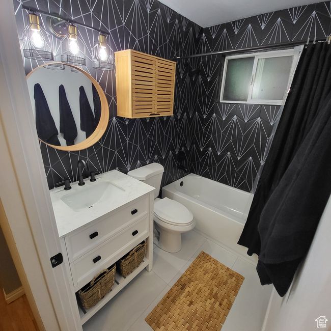 Full bathroom with vanity, tile patterned floors, shower / bath combo, and tile walls | Image 5