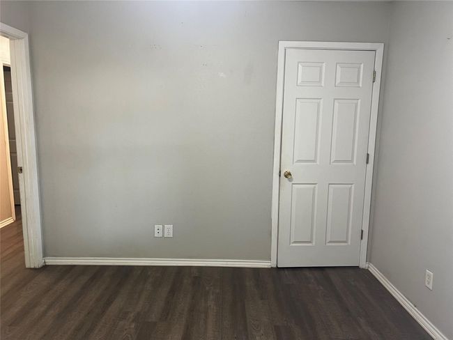 Unfurnished room with baseboards and dark wood finished floors | Image 9