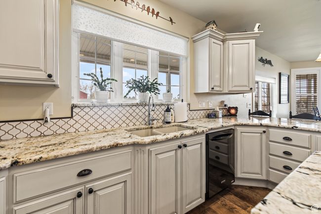 Kitchen with white cabinets, dark hardwood / wood-style floors, a healthy amount of sunlight, and sink | Image 27