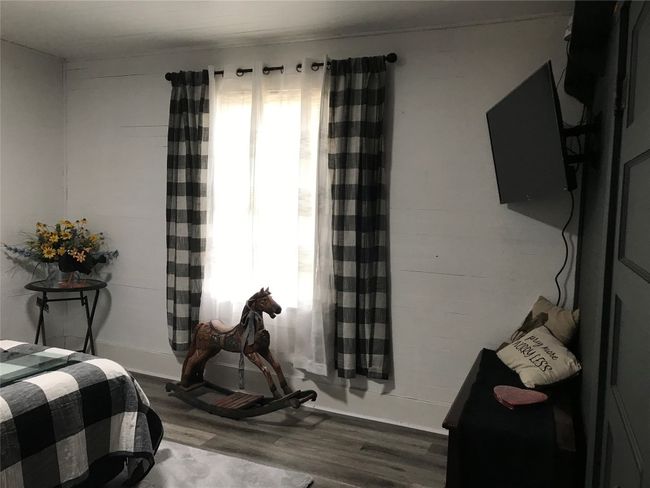 Bedroom with multiple windows and wood finished floors | Image 7
