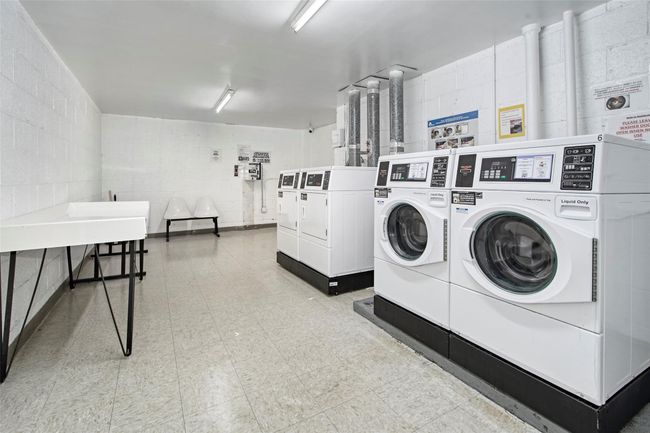 Shared laundry room featuring independent washer and dryer, concrete block wall, and tile patterned floors | Image 19