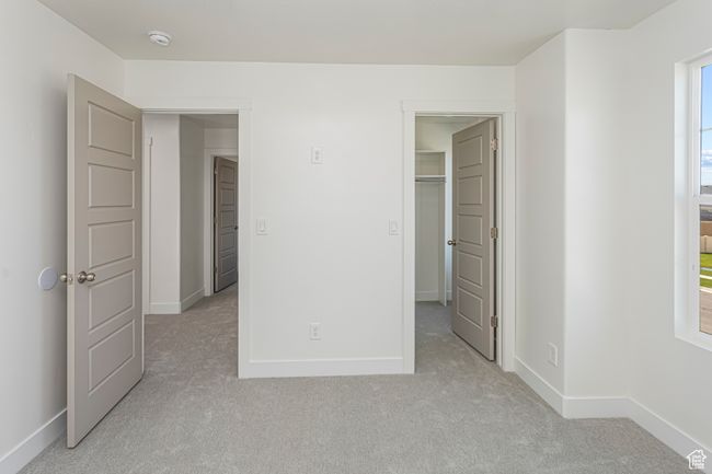 Unfurnished bedroom with baseboards, light carpet, and a spacious closet | Image 32