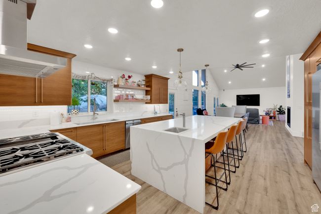 Kitchen with exhaust hood, a sink, dishwasher, backsplash, and recessed lighting | Image 4