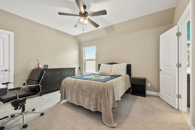 Bedroom 3 upstairs with light carpet, baseboards, ceiling fan, and lofted ceiling and walk in closet | Image 34