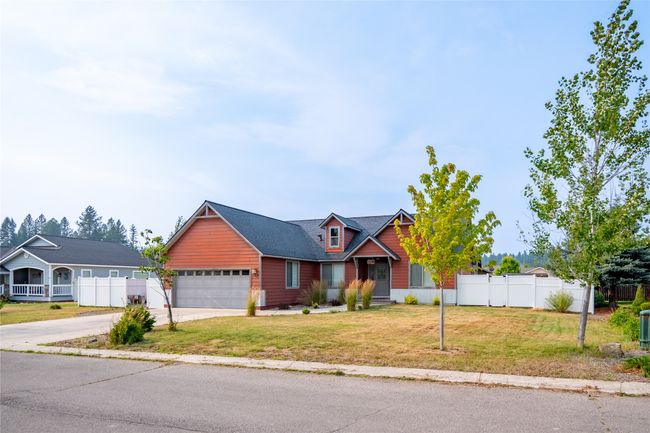 View of front of home featuring a garage, a front yard, fence, and concrete driveway | Image 8